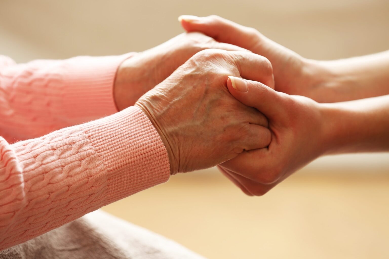 hand of a caregiver holding a patient's hand