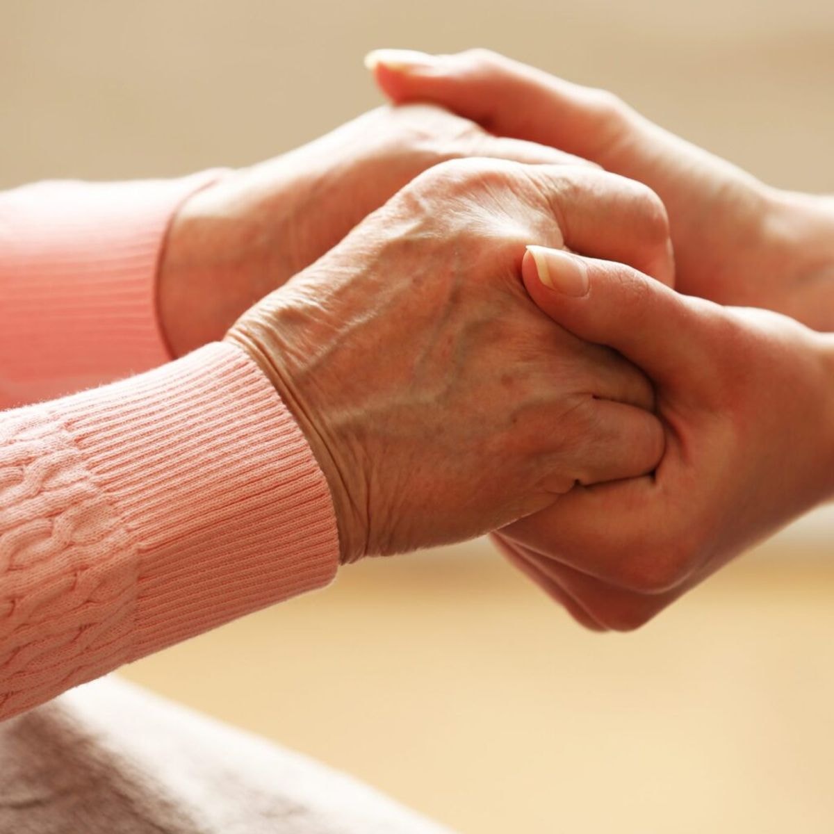 hand of a caregiver holding a patient's hand